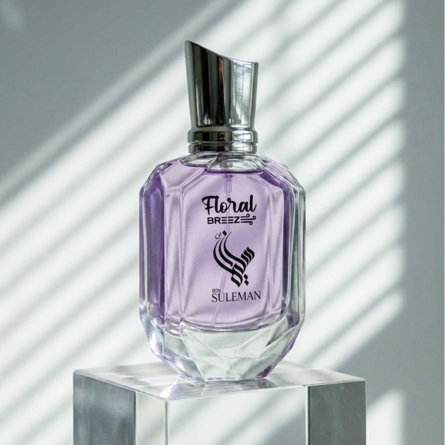 Perfume bottle labeled 'Floral Breez' by Suleman on a reflective surface with a light background
